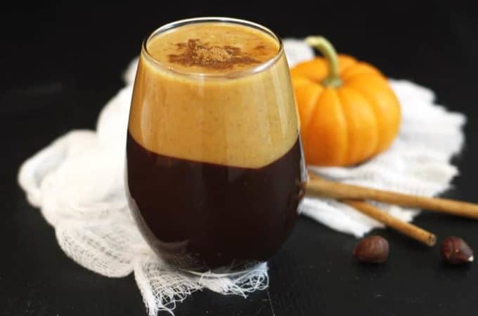 A glass coated in dark chocolate with a pumpkin latte inside.