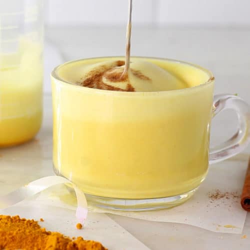 turmeric milk mug with the frother being pulled up