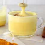 turmeric milk mug with the frother being pulled up