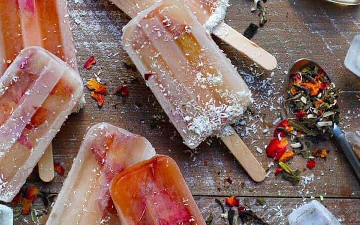 overhead view of white tea and plum popsicles with ice cubes