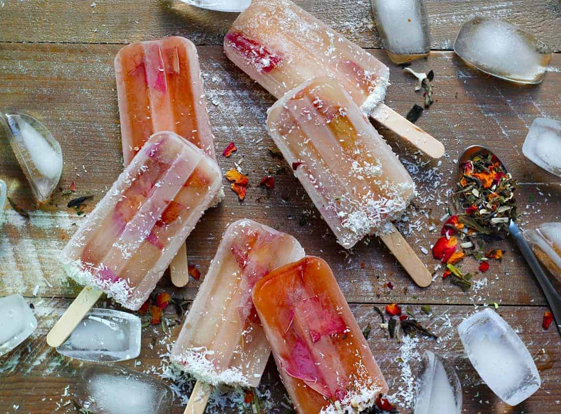 A scattering of white tea and plum popsicles on a wooden board.
