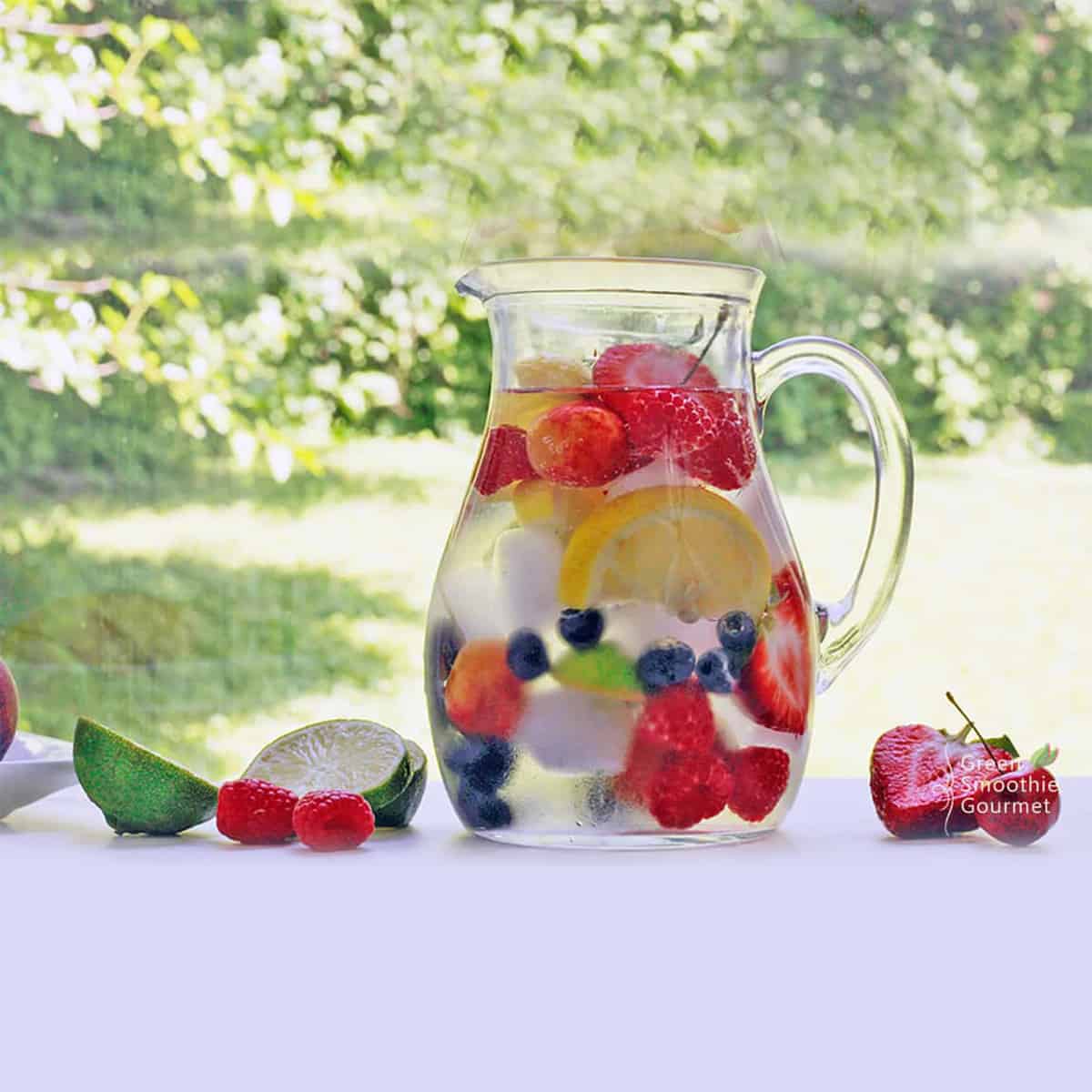 a pitcher full of water and fruit and ice