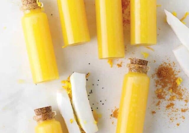 ginger shots in vials on a table with coconut.