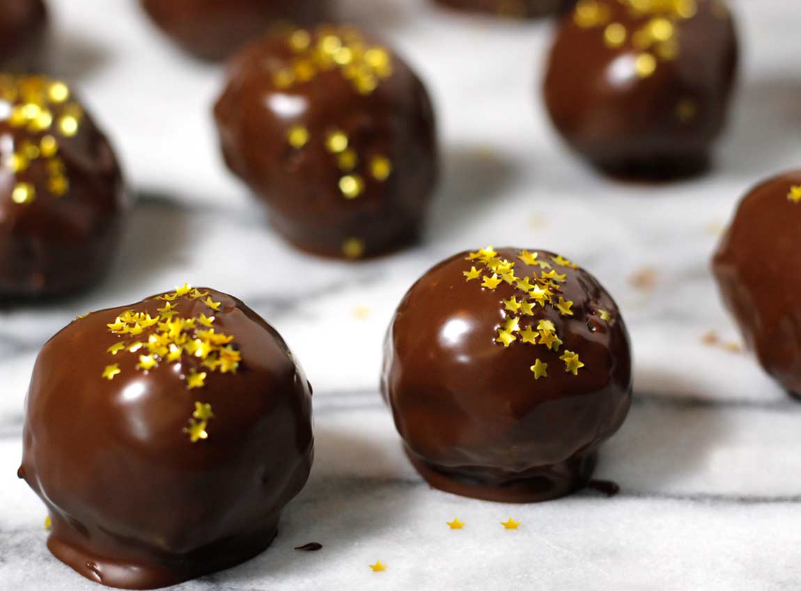 Chocolate coated easy truffles recipe in rows with stars on a marble board.