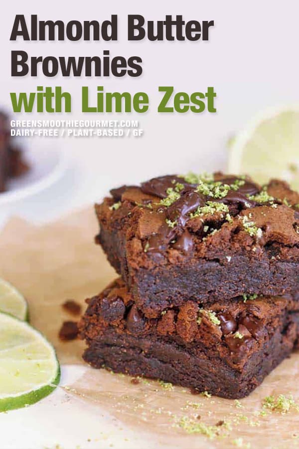 Almond butter brownies stacked on table with lime zest sprinkled on top.