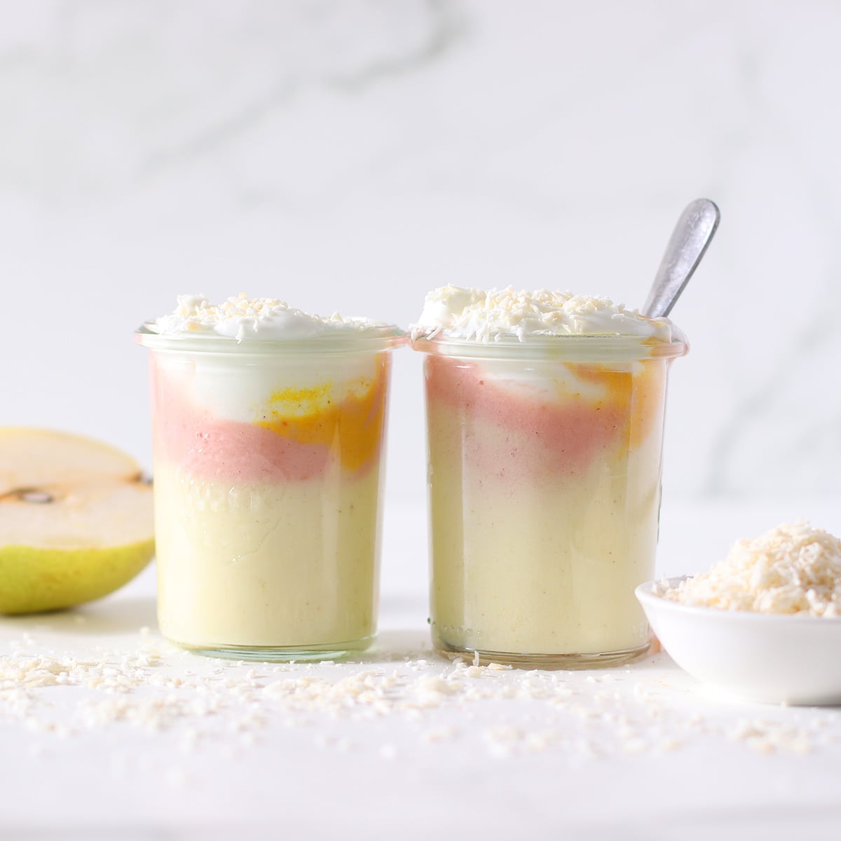 two pink pineapple smoothies in two glasses.