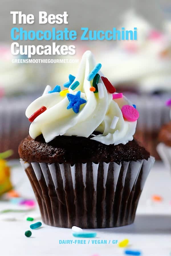 Chocolate cupcake with white icing with rainbow sprinkles on a white table.