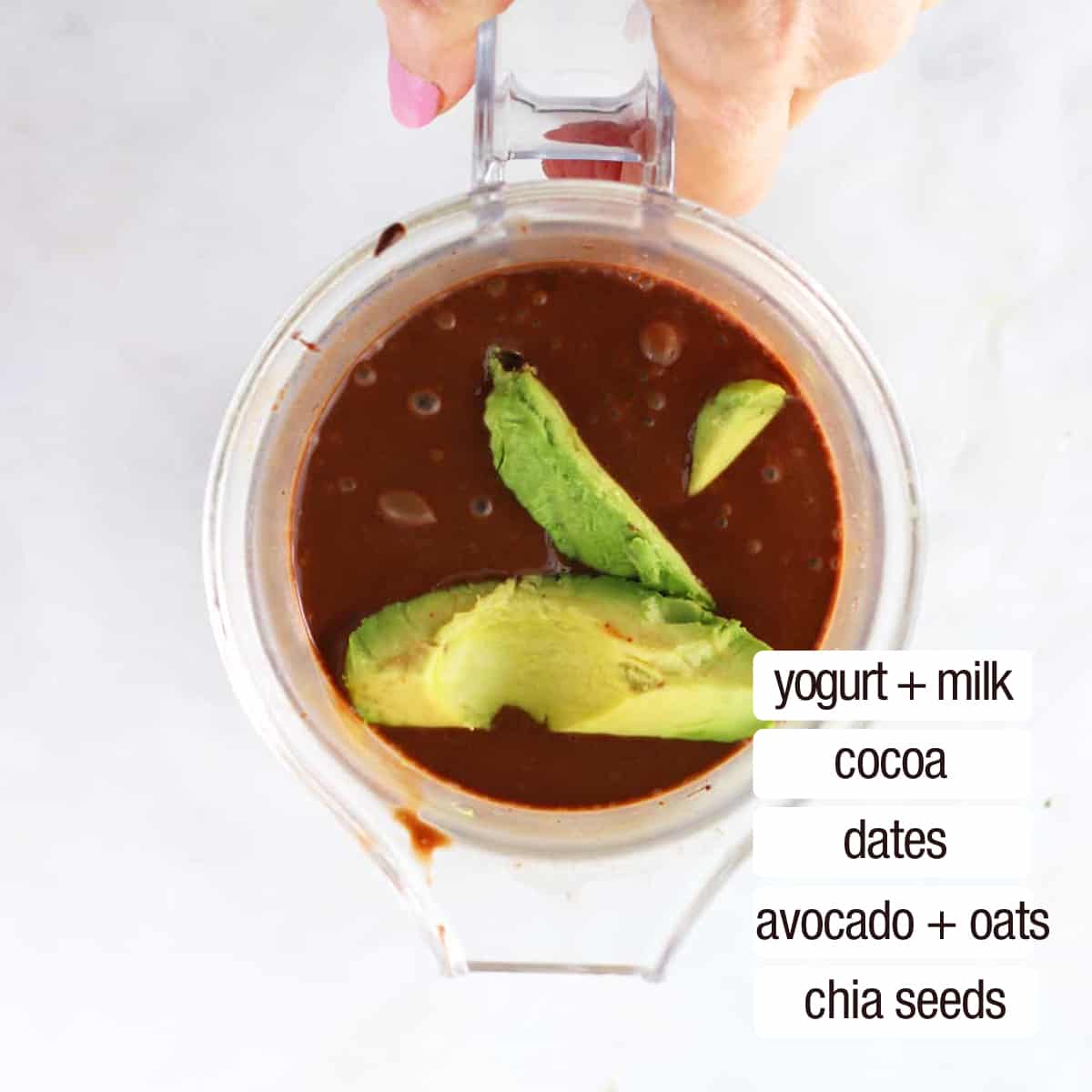 overhead view of chocolate smoothie and avocado in blender jar