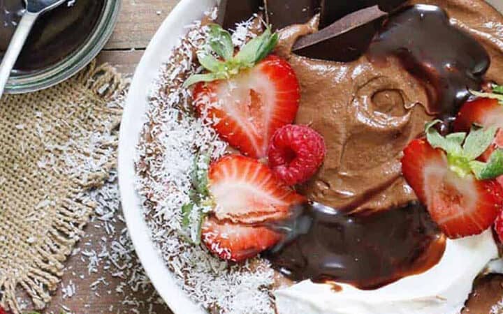 overhead view of chocolate smoothie bowl with chocolate chunks and strawberries on top