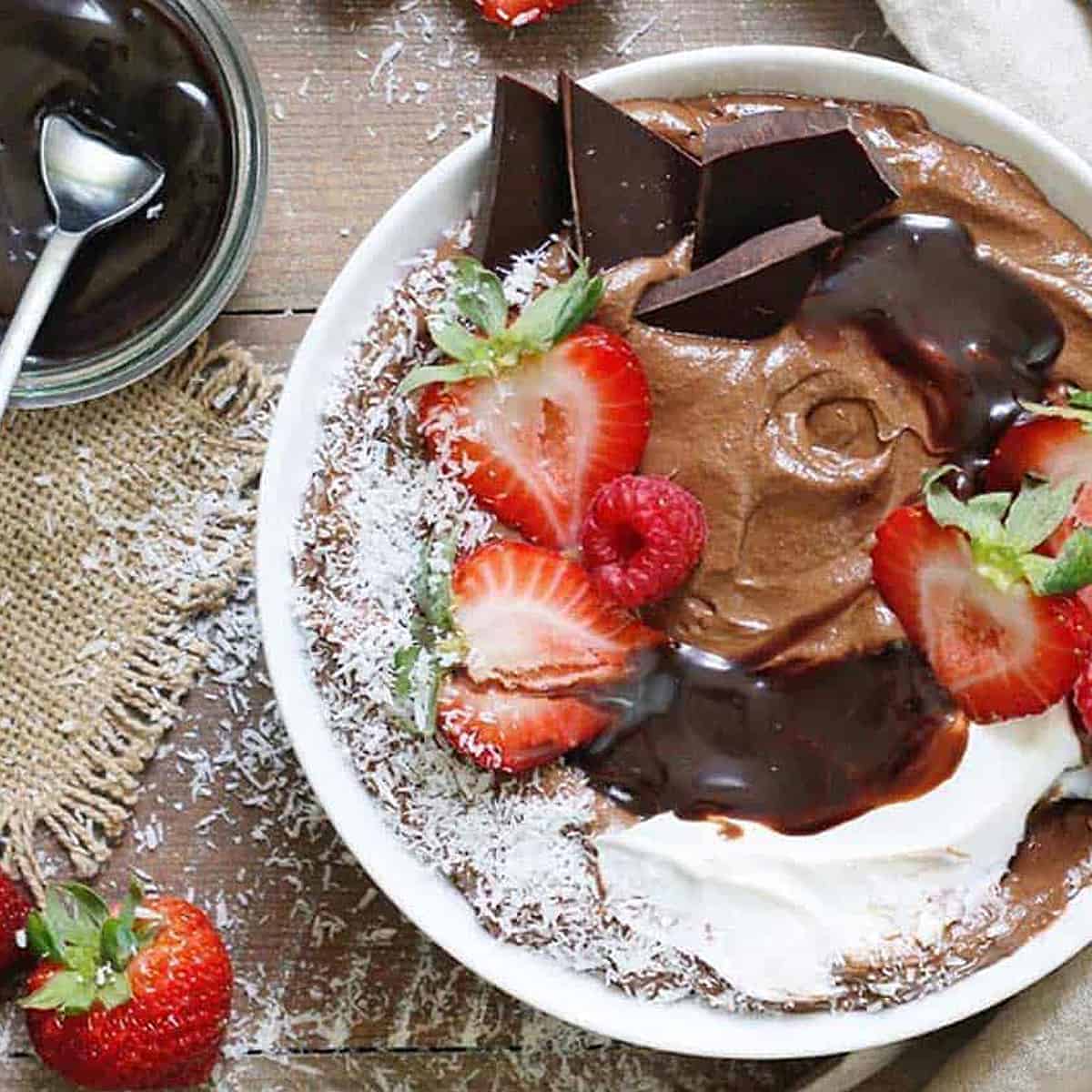 overhead view of chocolate smoothie bowl with chocolate chunks and strawberries on top