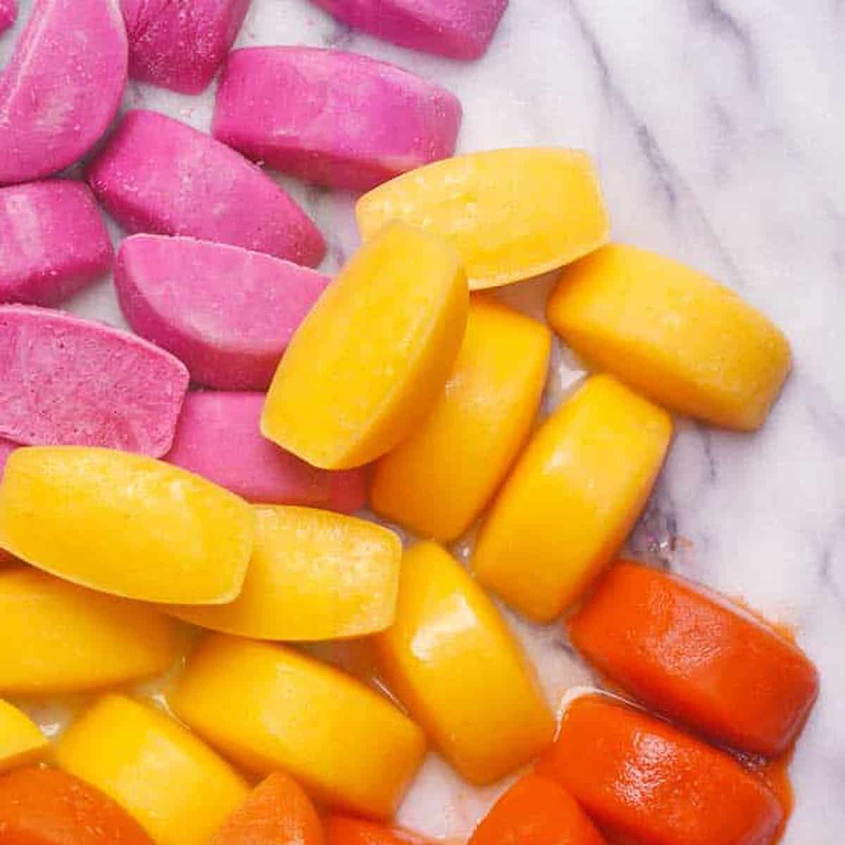 overnhead view of pink, yellow and orange smoothie cubes