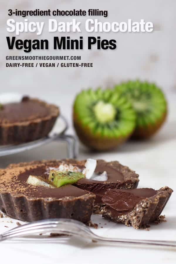 Straight on shot of a spicy dark chocolate vegan mini pie with a slice taken out and kiwi in the background.
