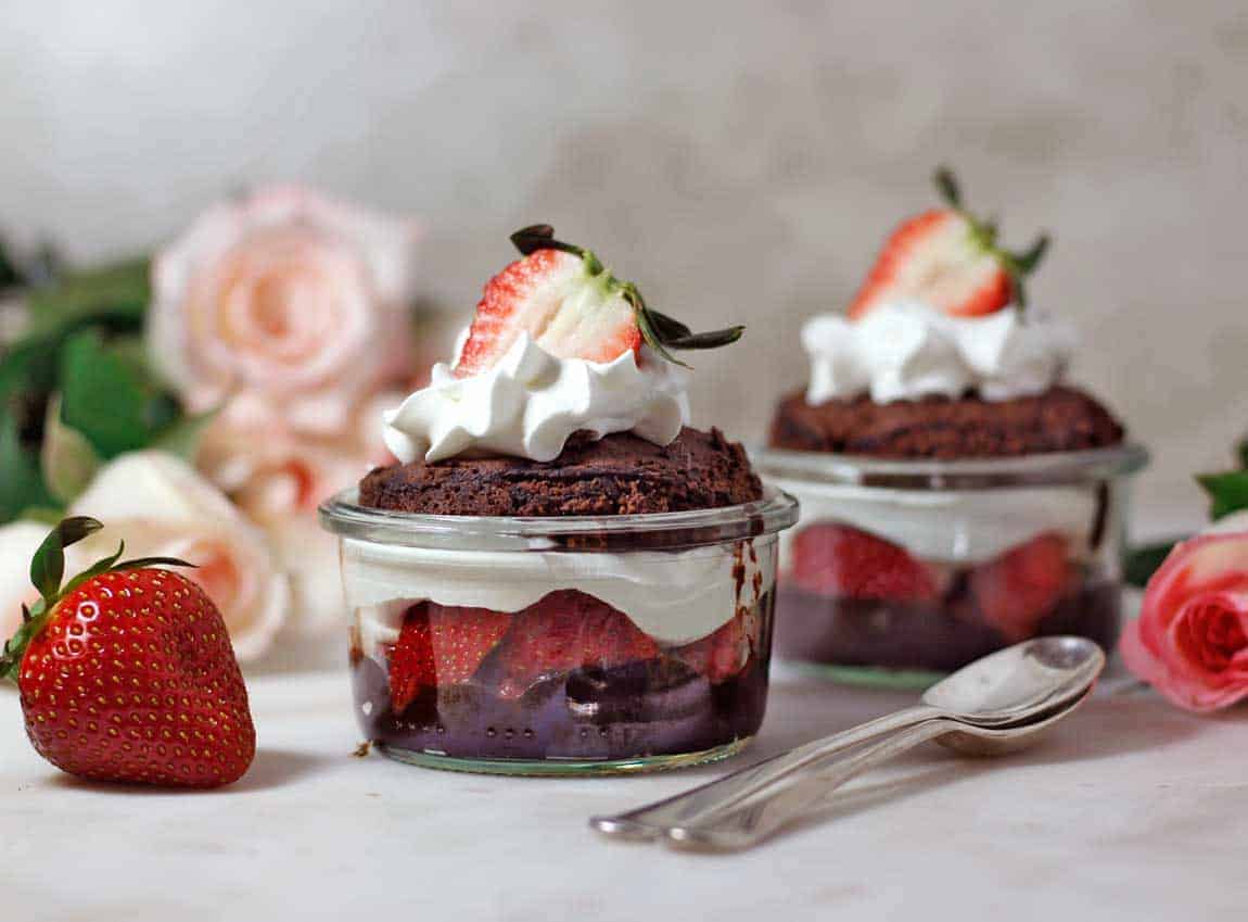 Vegan Chocolate Microwave Mugcake served sliced with strawberries and cream
