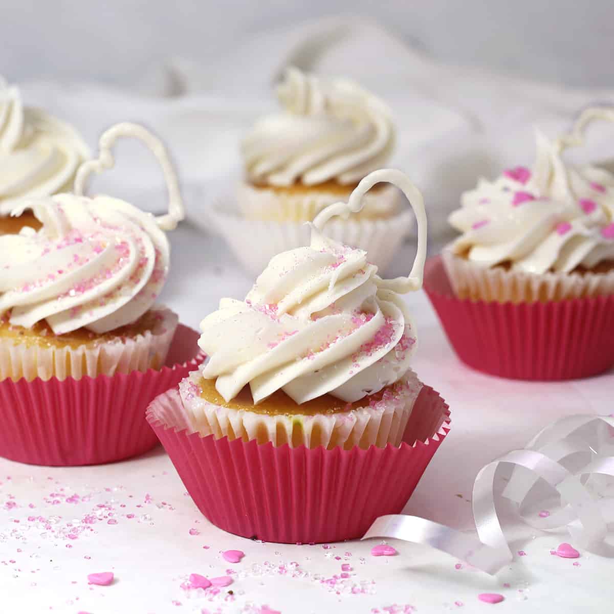 cupcakes with buttercream piped on top and pink paper cups