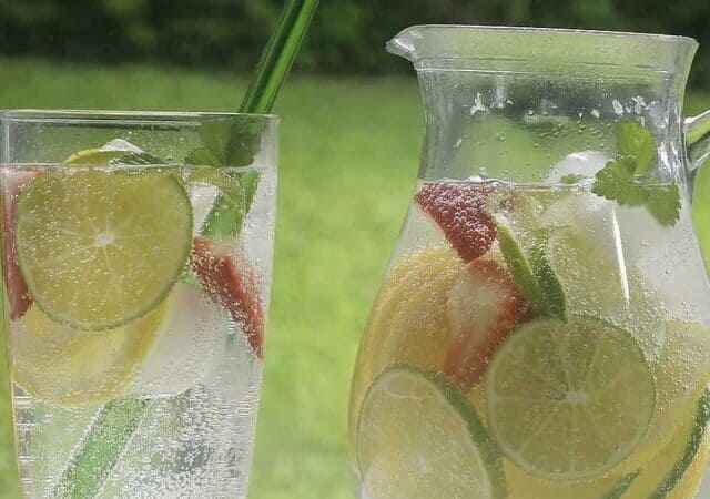 pitcher of citrus infused water with a glass.