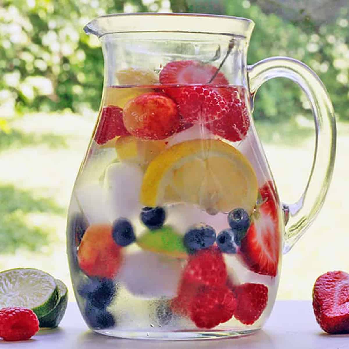 A pitcher of clear water with fruit