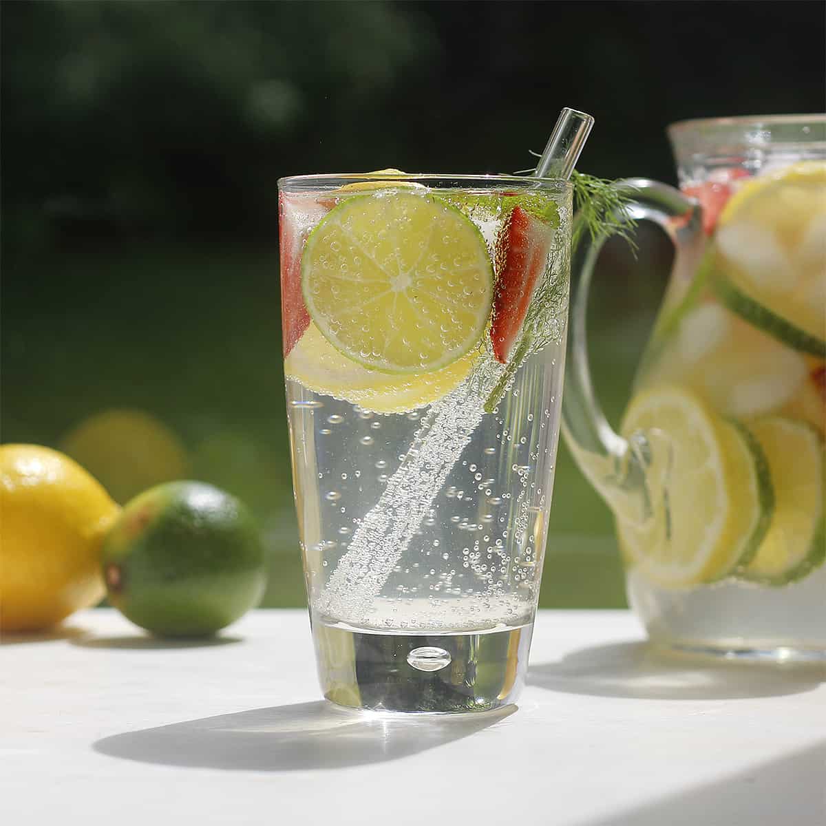 glass of infused water with a lime and straw.