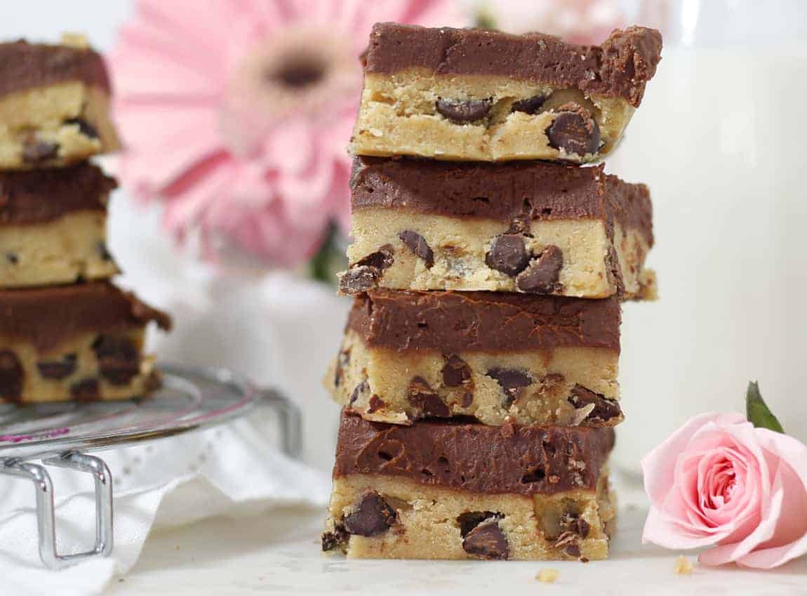 Stack of cookie dough bars with a pink flower behind them.