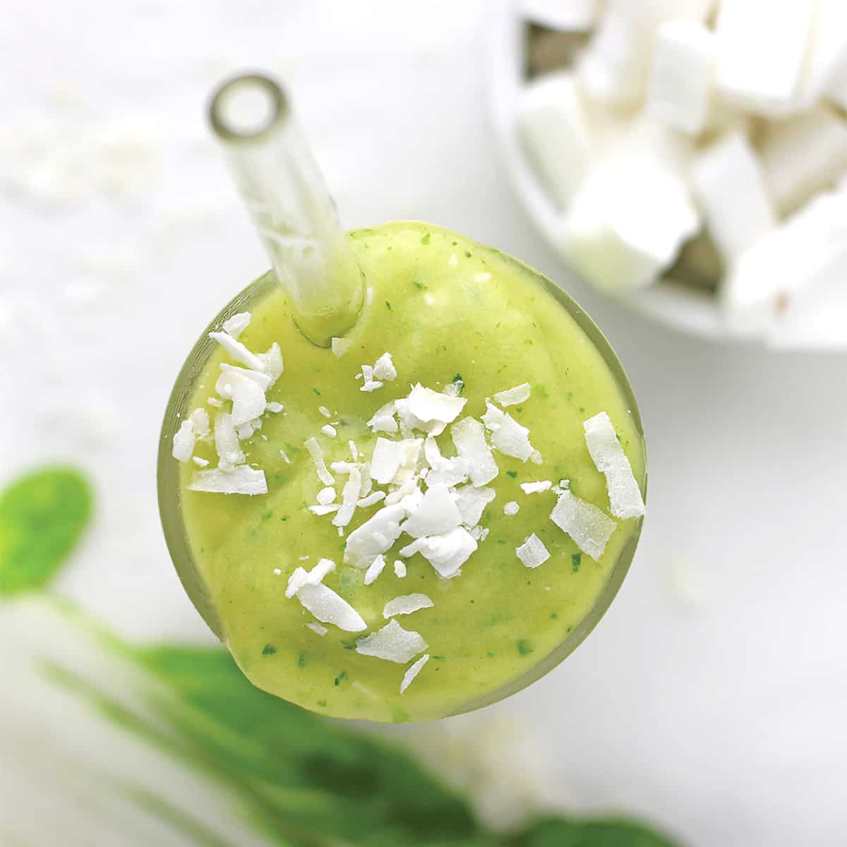 overhead view of green weight loss smoothie with glass straw