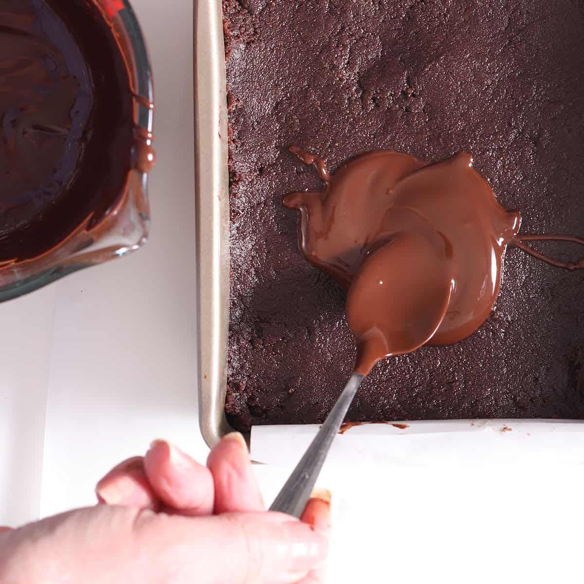 chocolate being spread by a spoon on a batter
