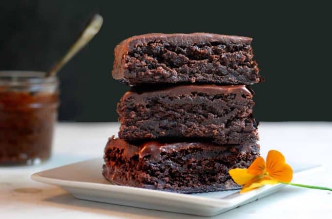 Stack of three brownies with a black background.