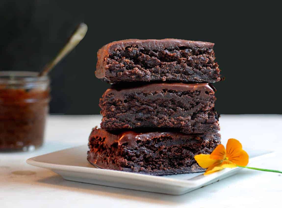 Stack of three brownies with a black background.