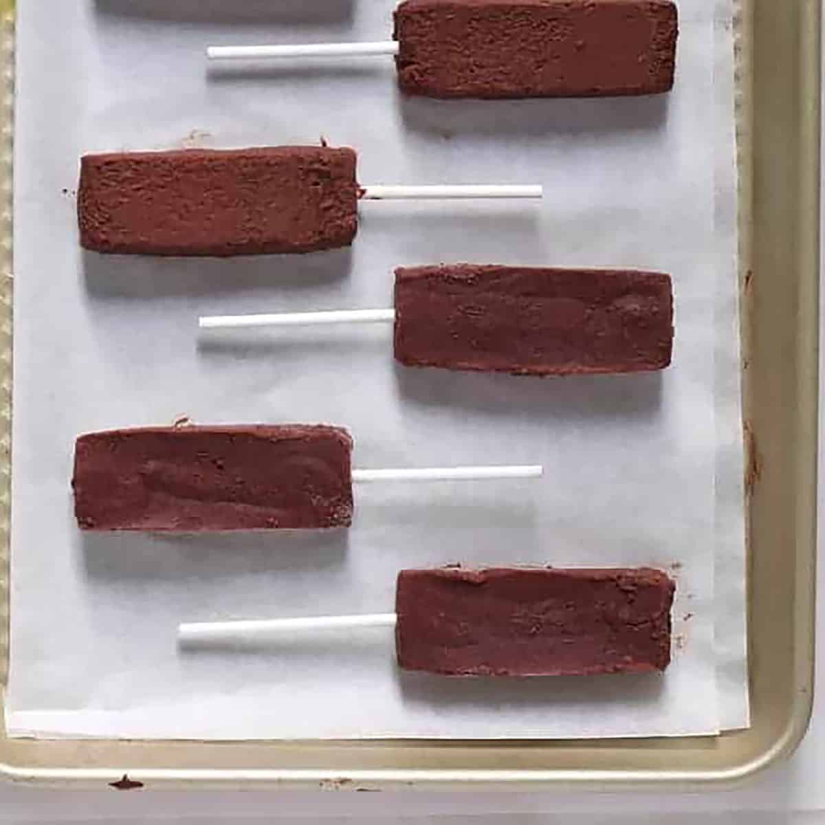 mars bars on a tray with lollipop sticks.