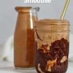 Peanut butter smoothie in a jar on a white plate.
