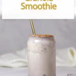 granola smoothie in a glass with a gold straw