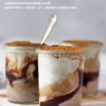 Three jars of healthy homemade mascarpone layered with fudge and cookie crumbs on a white table.