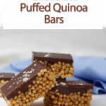 chocolate puffed quinoa bars stacked with a blue cloth.