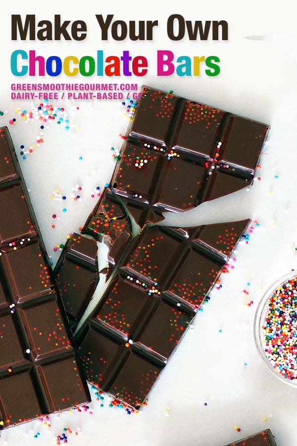 Two homemade chocolate bars on a marble board, broken and with sprinkles.