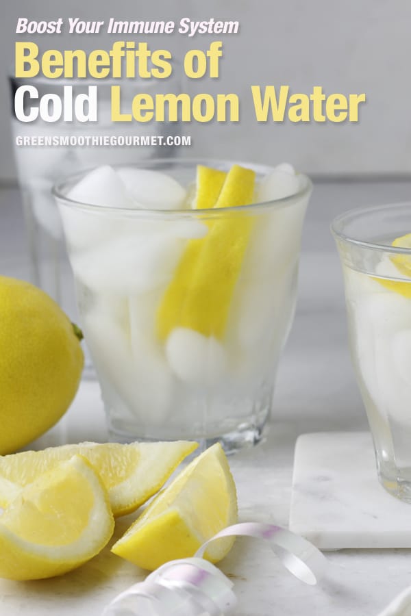 An iced glass of cold lemon water on a marble board.