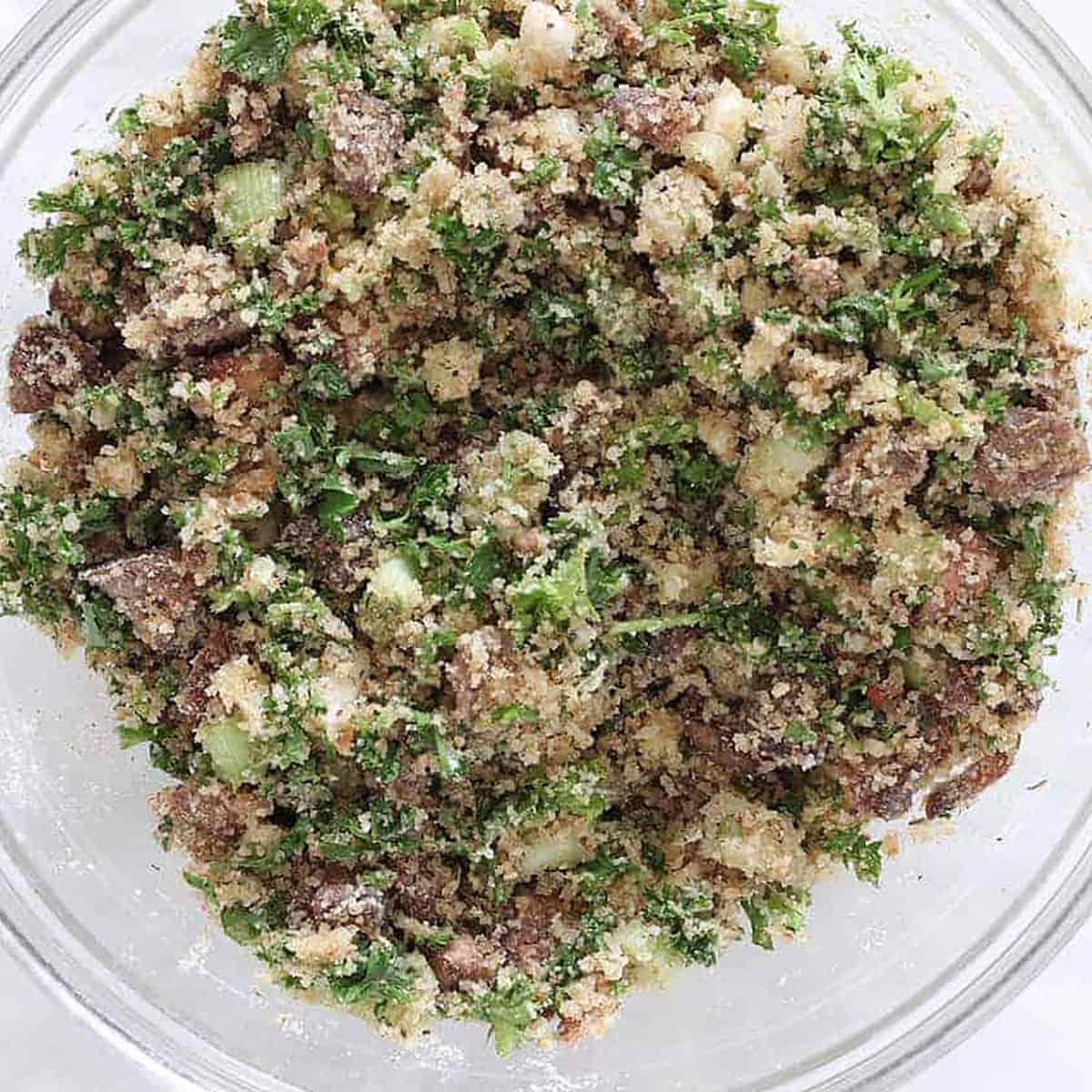 stuffing in a bowl with parsley and parmesan cheese.