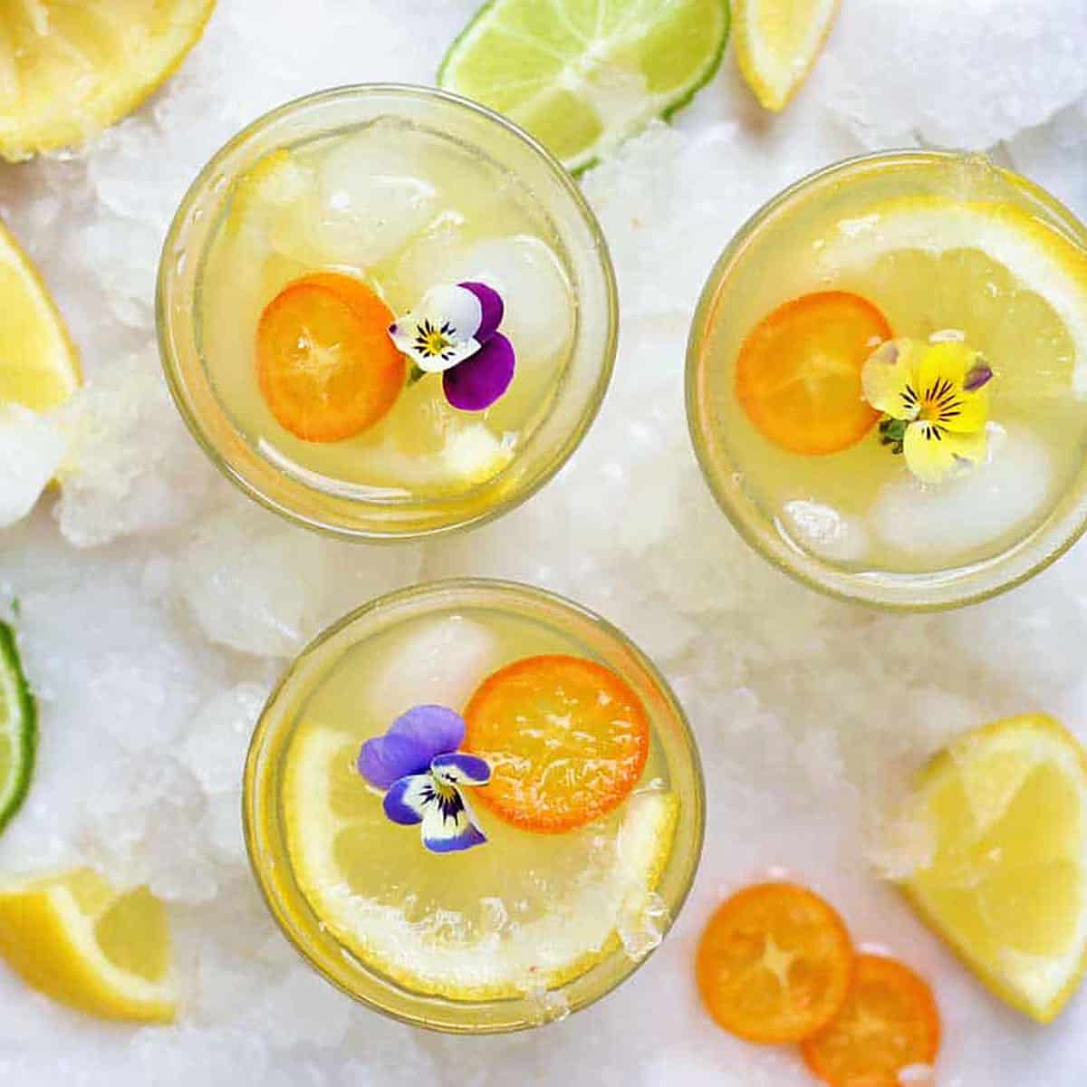 overhead of lemon water in a lemonade with flowers.