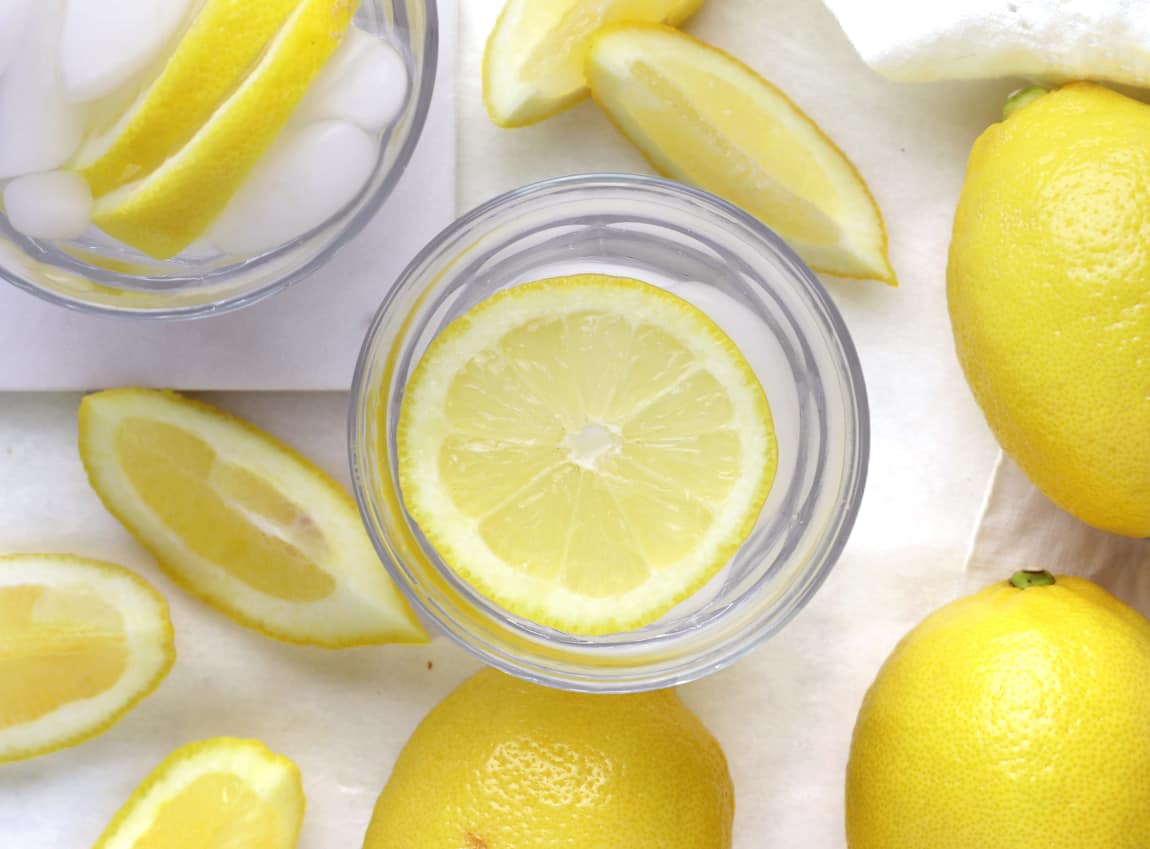  Un verre glacé d'eau froide citronnée sur une planche de marbre.