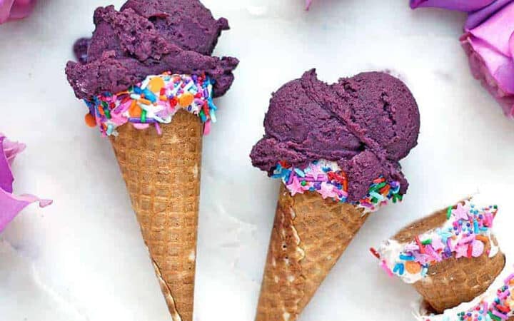 two blueberry ice cream cones on their side
