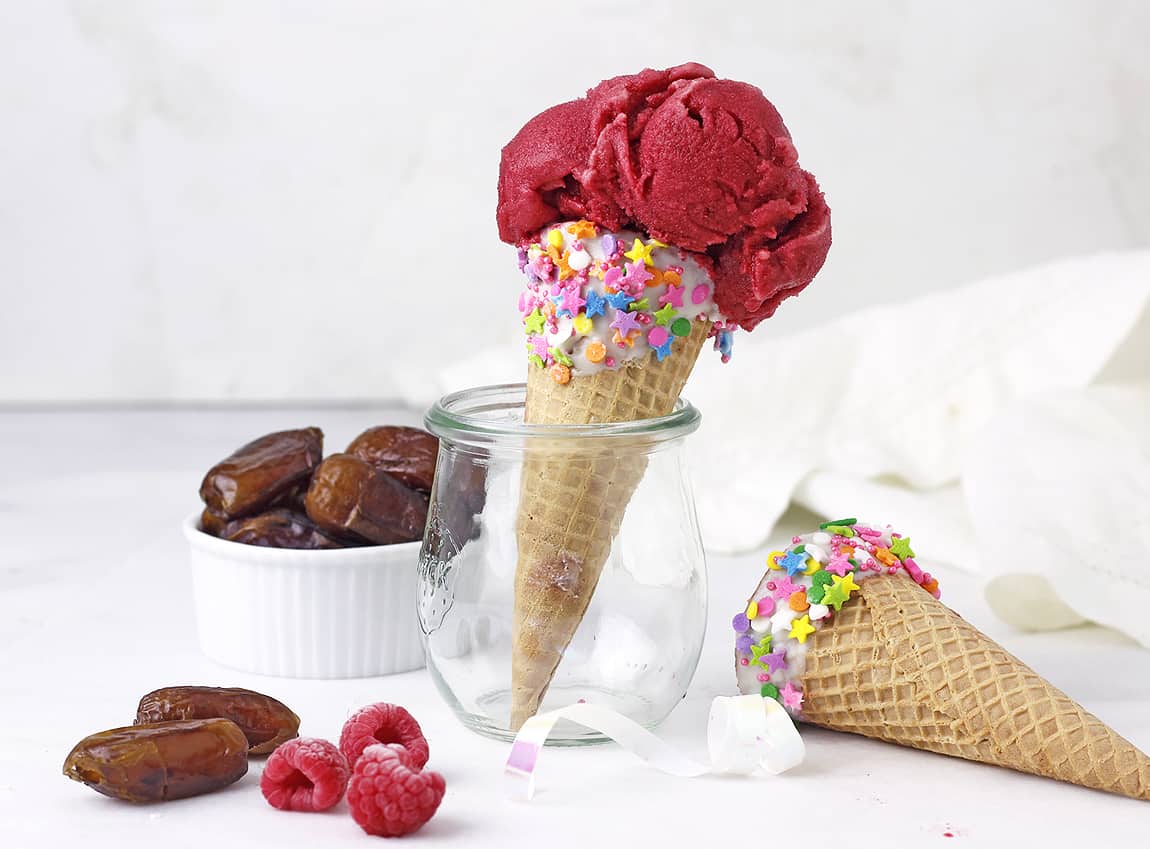 Date Raspberry Ice Cream on a White table with date paste nearby.