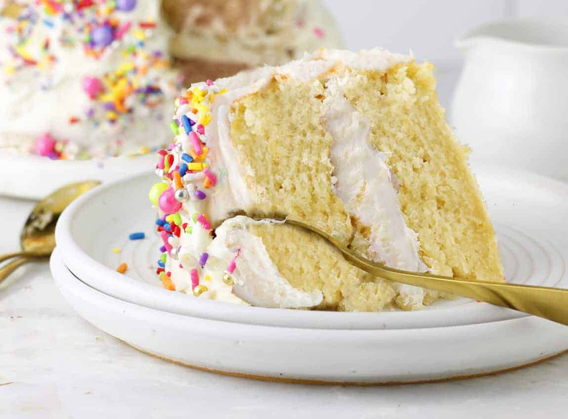 Vanilla vegan cake sliced with cake in background.
