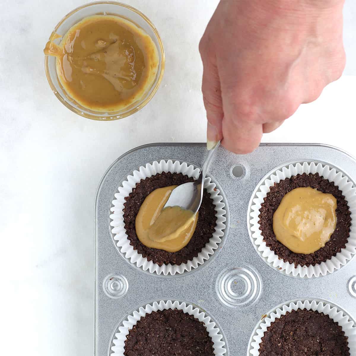 chocolate peanut butter cups with spoon adding peanut butter.