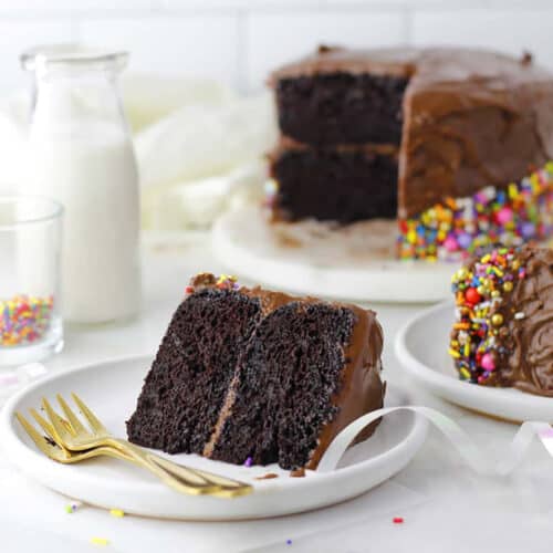 a slice of dairy free chocolate cake with chocolate icing and sprinkles