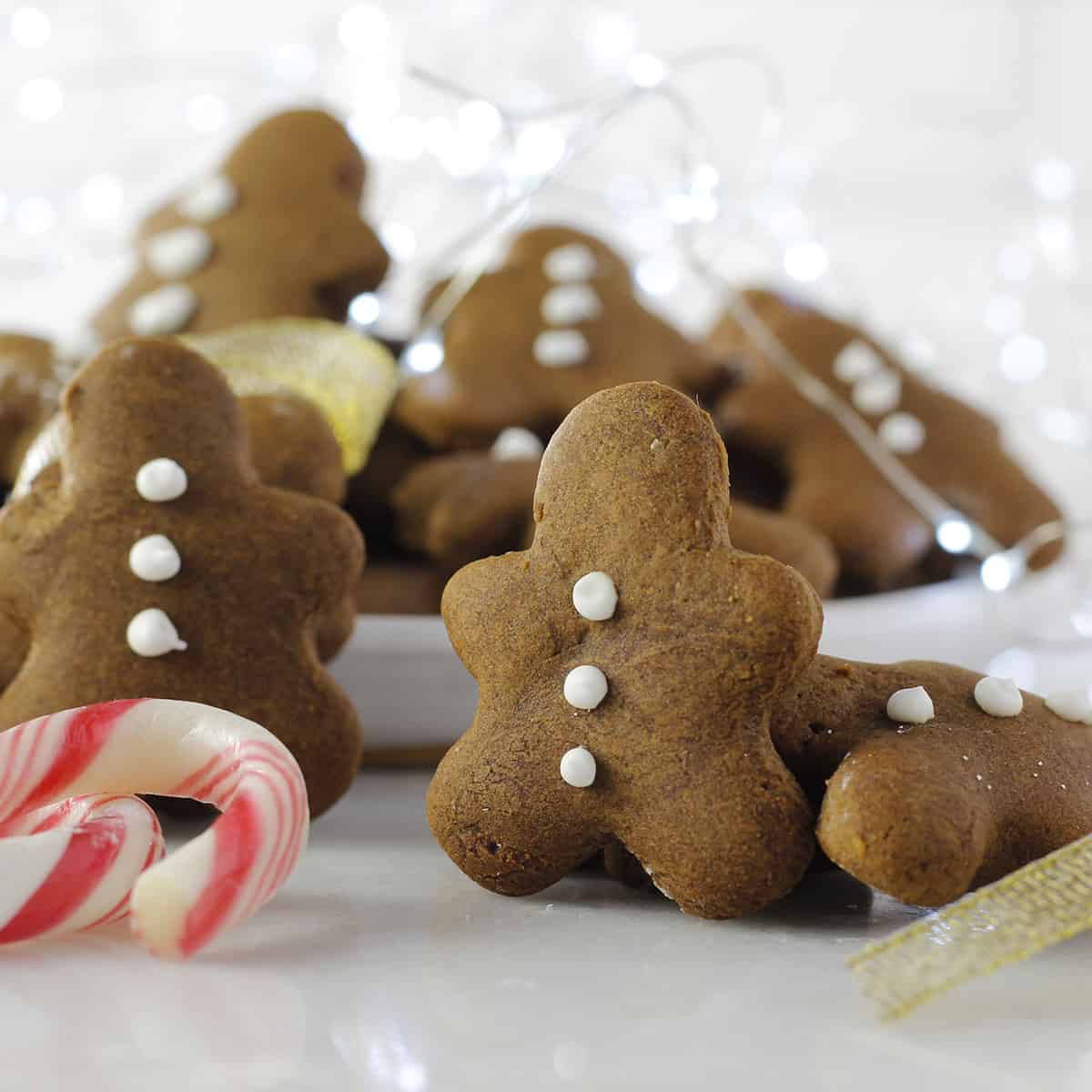 gingerbread men standing with a candy cane.