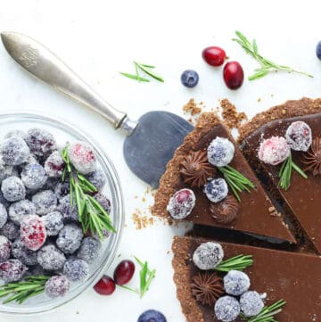 overhead of sugared berries on a chocolate pie slice