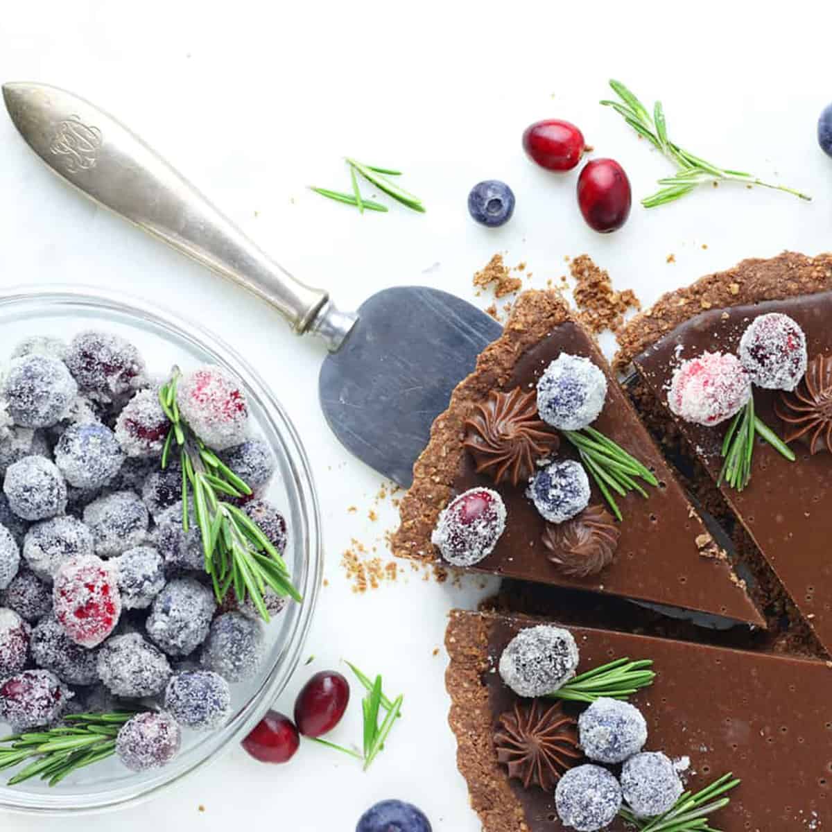 overhead of sugared berries on a chocolate pie slice