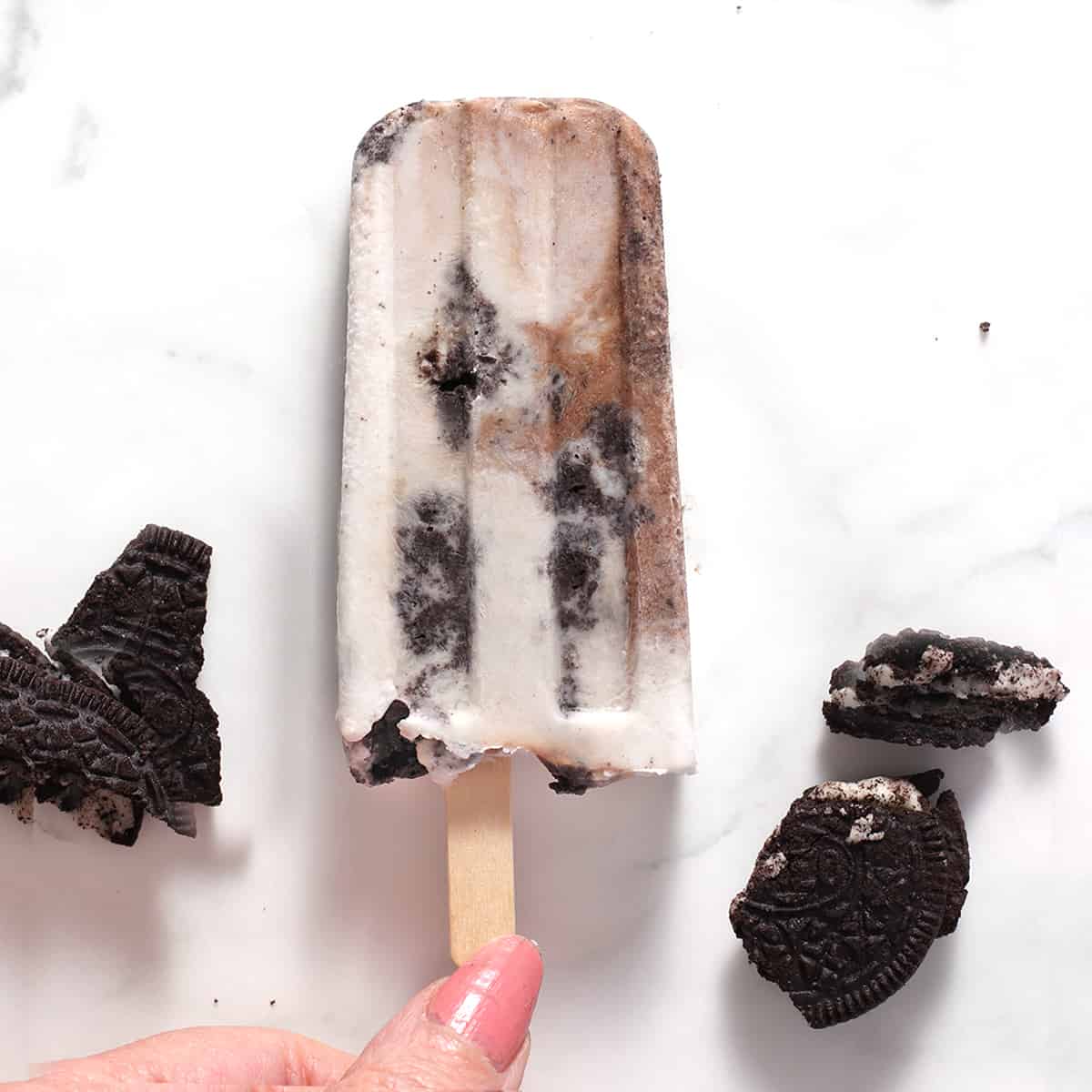one cookies and cream popsicle on white marble