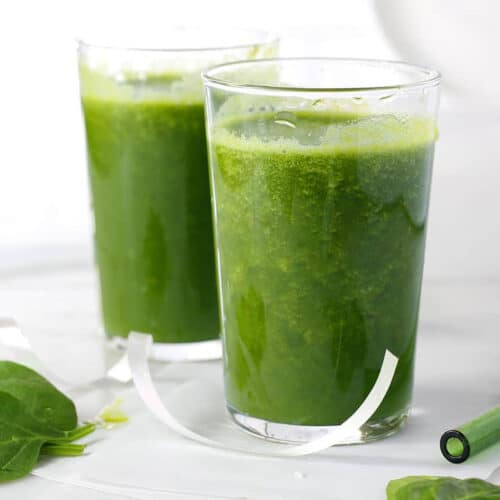 two glasses of green smoothie and a straw