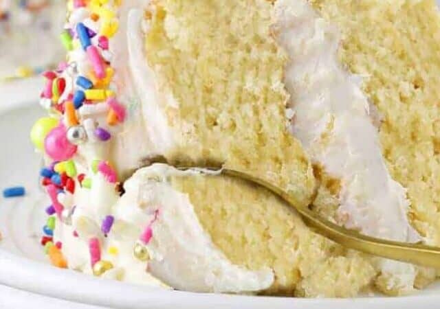 slice of vanilla cake with white frosting and sprinkles.