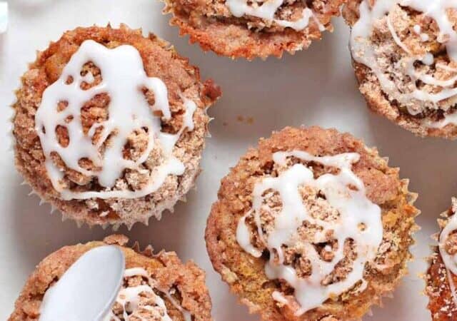 pumpkin muffins with glaze being poured.