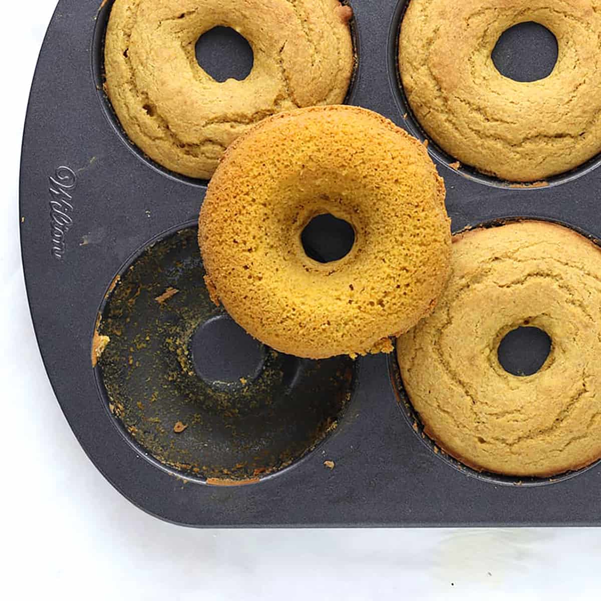 baked pumpkin donuts in a pan.