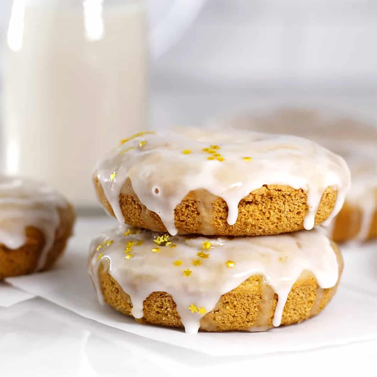 a stack of pumpkin donuts with glaze and golden stars.